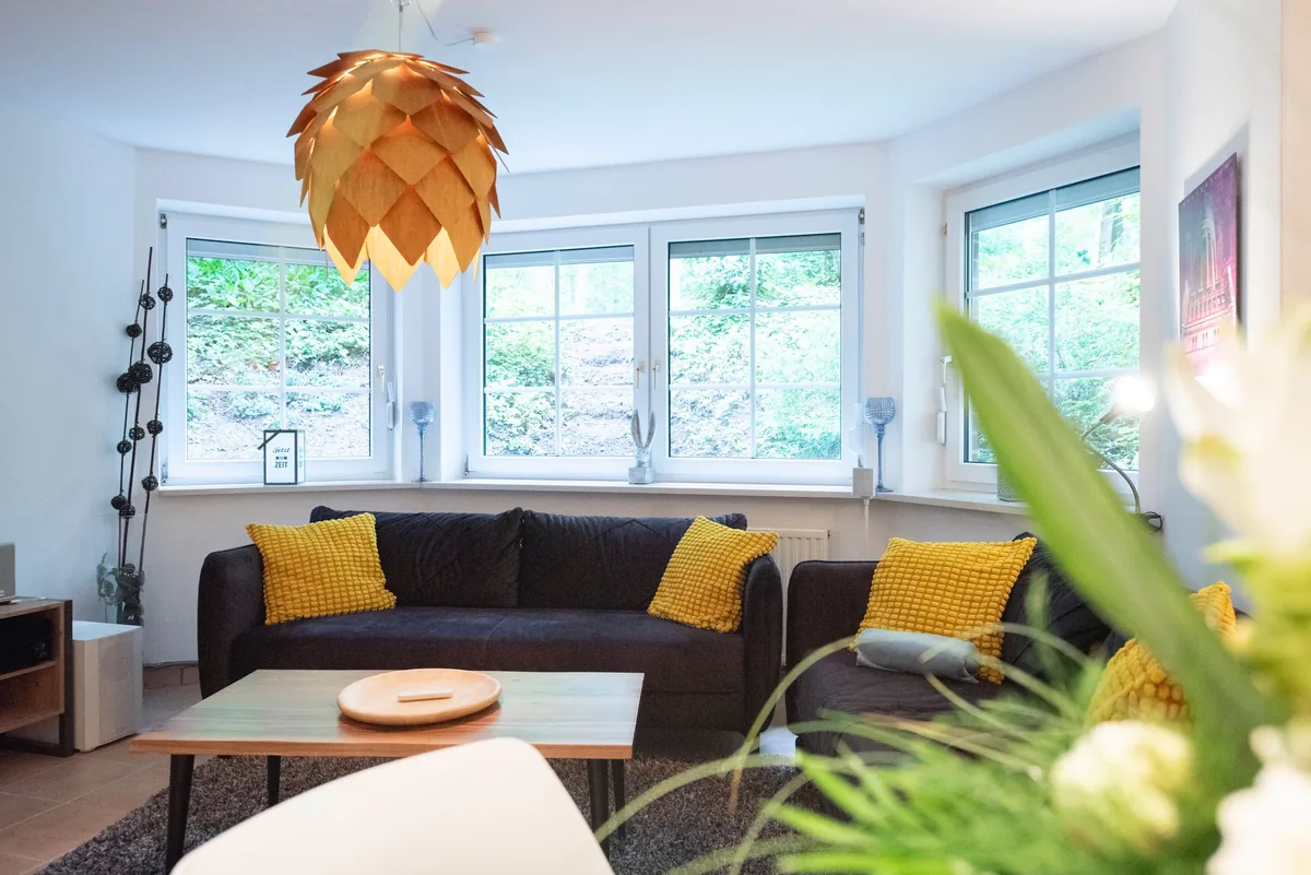 Schnuckenstube Wohnzimmer mit Sofa und Tannenzapfenlampe